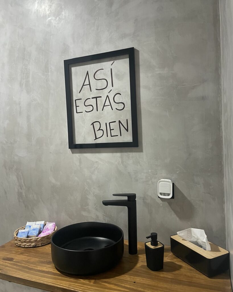 Zona de lavado del centro con el cuadro Así estás bien